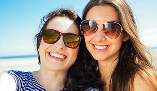 Two women wearing sunglasses at the beach