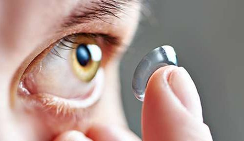 Man putting a contact lens in his eye