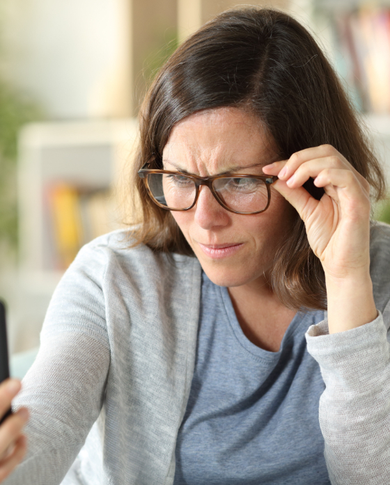Woman with blurry vision adjusting her glasses