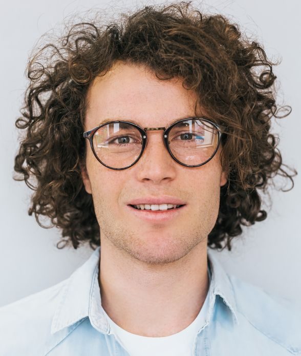 Man with curly hair wearing prescription eyeglasses