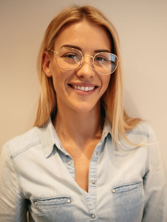 Young blonde woman wearing glasses and a blue shirt